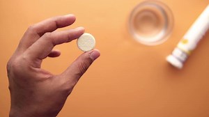 Effervescent tablet held above table