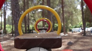 Close-Up of swing swinging. POV of the swing. People doing different activities in the background. Blurred background.