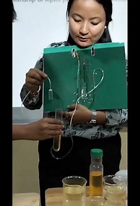 DIY manometer dipped in liquid samples to measure liquid pressure at varied depths.