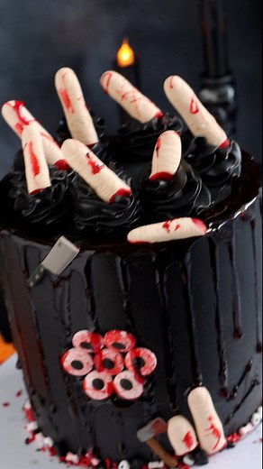 Creepy cake anyone?! 👀🖤🩸 We love how Find Your Cake Inspiration indulged their dark side with our Blood Red Glaze, Candy Eyeballs, and Severed Finger Icing Decorations! | Wilton Cake Decorating