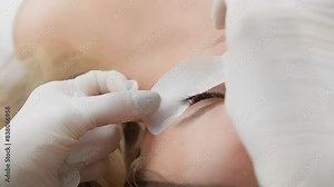 A detailed look at the stepbystep process of applying eyelash extensions by a professional beautician, ensuring precision and care for enhancing the beauty of the eyes and lashes in a salon setting