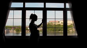 clip-1056323663-silhouette-pregnant-woman-shade-by-window-photographed