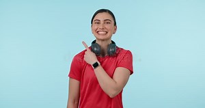 Headphones, pointing finger and portrait a woman in studio for advertising, announcement or mockup. Face of a happy
