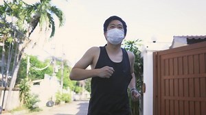 clip-1072496858-young-asian-man-running-face-mask-city