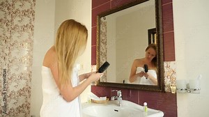 Slow movement of female dry wet hair. A female woman uses a hairdryer in the bathroom. 4k