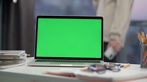 Laptop Computer Showing Green Chroma Key Screen Stands On Desk In Room or Office