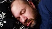 Male snoring. A grown man is asleep and his lips move from snoring.