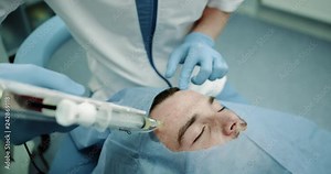 Portrait of modern procedure with microneedling young patient have a vampire facial prp procedure on his face patient have close eyes and are laying down on cosmetology chair. 4k