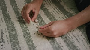 High-angle close-up of hands of anonymous young male or female person with hearing loss taking apart electronic cochlear ear implant with sound processor, transmitter and battery for maintenance
