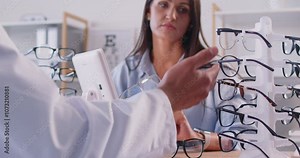 Patient receiving expert advice from an ophthalmologist doctor while choosing eyeglasses for vision correction. Eye care and the importance of selecting suitable eyewear under healthcare guidance.
