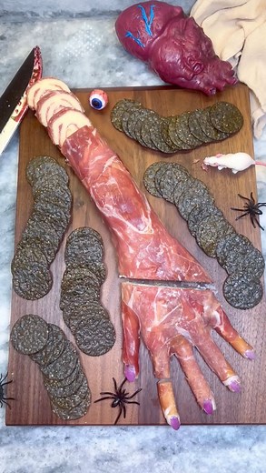 Edible Amputated Hand. Follow @chefgenevieve for 30 Halloween inspired recipes. Inspired by: @ghoul.at.heart 16oz cream cheese, room temperature 1 T minced chive 1 T minced parsley 1 T minced Dill 1/2 tsp salt 1/2 tsp pepper 1/2 tsp garlic powder 1/2 tsp garlic powder 5 Panino rolls 2 Prosciutto wrapped mozarella rolls 5 slices prosciutto Red onion To a bowl, combine cream cheese with herbs and spices. Lay a sheet of parchment paper down, trace out your hand and lower arm then place another shee