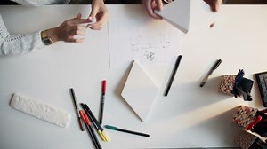 Top view of creative hands working on paper models and diagrams - Free Stock Video