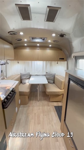 🌟 Just arrived at Sutton RV and I'm already in love with the Flying Cloud 19 travel trailer by Airstream—perfect for a weekend escape! 🌟🚪 Right by the entrance, there's a cozy dinette waiting to host our meals and chats. 🍳 The galley is fully equipped with a pantry, fridge, and even an LED TV above the refrigerator for entertainment while cooking! Across, you'll find a sink and a three-burner range to make any chef envious.🚿 The bathroom doesn't skimp on essentials, offering both a shower a