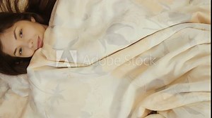 Beautiful girl bask in bed under the blanket