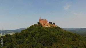 Cinematic drone shot of Burg Hohenzollern near Bisingen, Baden-Wuerttemberg, Germany. Iconic medieval castle on Mount Hohenzollern with epic views of Swabian Alb forests and German history.