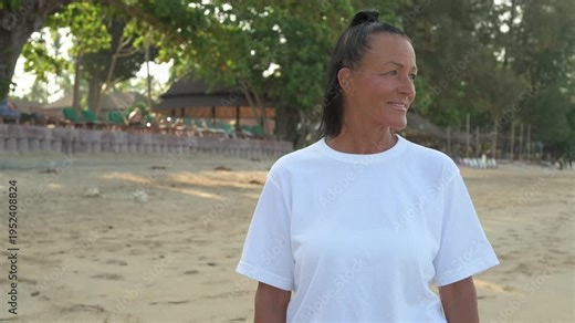 Happy Scandinavian mature tourist woman wearing 90s inspired normcore clothing in Thailand beach