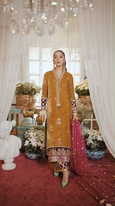 Remi- Winter Velvets by Annus Abrar | Aylin - Long silhouette velvet shirt in ochre colour featuring fuchsia and maroon colour blocked hemline. The overlapping neckline is adorned with zarodozi and pearl’s details. The shirt is paired with pure raw silk gota izaar in deep maroon colour. The shirt is paired with deep pink organza dupatta featuring sequins all over. Shop Now: www.annusabrar.net/aylin For more details, kindly inbox or call/whatsapp us at 92-303-3333710 or email us at sales@annusabr