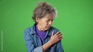Portrait of elderly mature old woman with health problem shoulder pain, with wrinkled skin and grey hair on green screen background.