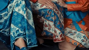 Close-up of traditional Asian attire with intricate patterns, focusing on the fabric and elegant designs.