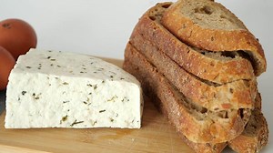 herb cheese and slice of brown bread on table