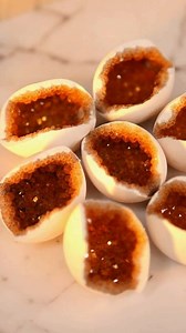 Mix 3/4 cup alum powder with 2 cups boiling water (or supersaturate sugar water). Add brown food coloring (or mix red and green) with a drop of orange/yellow to get the amber shade. Pour into shells prepped with glue and alum/sugar dust. Let sit 12–24 hours. The amber color mimics natural citrine or "dragon egg" septarian geodes. #CrystalGrowin #BoraxCrystals #STEMCraft #DIYOrnaments #ScienceArt | Hello Quick recipes