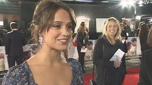 Alicia Vikander gives a peek at legs in dress with a thigh-high split