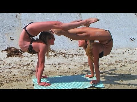 Acrobatic duet. Two flexible girls doing contortion on the beach. Contortionist Alesya and Julia.