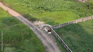 Man collecting garbage from land filled with disposal of plastic waste material 4K slow motion footage India dump junk landfilling construction cause environmental issues pollution global warming.
