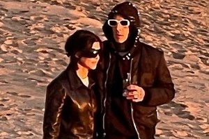 Kourtney and Travis hold hands during romantic stroll on the beach in Montecito