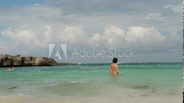 Footage of a bikini girl walking into tropical beach in Mexican Caribbean