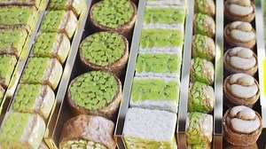 selling turkish buklava adorned with nuts and flavors at market