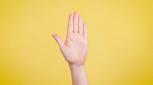 clip-1031372159-hand-held-stop-position-on-yellow-backdrop