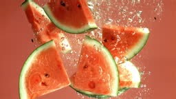 Watermelon slices fall under the water. Filmed on a high-speed camera...