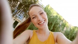 Woman taking selfies videos of herself on camera