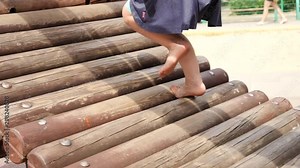 Barefoot legs kid girl play on park playground for children enjoy to be barefooted outdoor slow motion