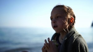 Child eating apple beach. Having snack on the beach. Girl at the resort.
