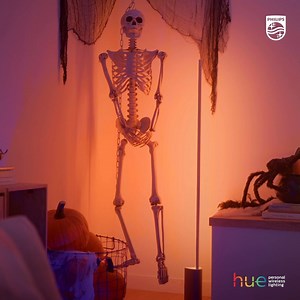 The long, slender light of the Hue Signe floor lamp and a spindly skeleton make the perfect Halloween pair. Get more Halloween lighting ideas: https://philips.to/2GJTSLW #PhilipsHue #SmartLighting #SmartHome | Philips Hue