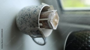 Hot water poured into a cup of roasted coffee to produce fresh drip coffee. Making coffee with drip coffee bag. Human gently pours hot water on the surface of the ground coffee. Wetting the coffee