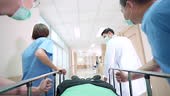Patient on hospital gurney stretcher bed being transported down the...