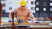 Strong construction worker on construction site, wearing protective...