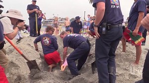 Lifeguards and emergency workers in Encinitas demonstrate the dangers of digging deep holes at the beach. [story: http://bit.ly/294xeLs] | The San Diego Union-Tribune