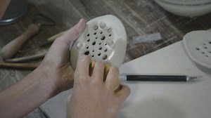 Woman using a wet sponge on a clay object - Free Stock Video