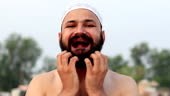 Young shirtless Muslim men scratching his beard close-up portrait.