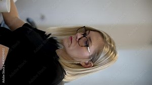 A vertical video captures a female office worker seated at her desk, panning across different monitor screens, illustrating the concept of multitasking in a modern workplace.