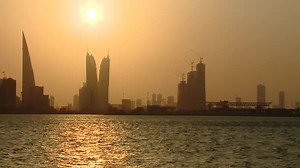 Timelapse sunset to night of the Manama, Bahrain skyline showing the Bahrain World Trade Centre (WTC