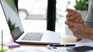 Businessman working on typing laptop in office having chronic hand pain and wrist pain.