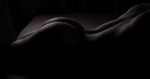 Des fesses masculines nues et sexy, allongées sur un lit