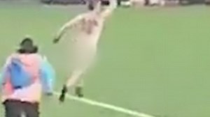 Video shows man sitting in the crowd before streaking on the pitch
