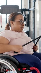 「縦長動画：ケーブルを握る、車椅子の女性はジムでトーンを引き下げ、コピー用スペース。適応型スポーツ、筋力トレーニング、フィットネス機器、インクルーシブジム、生体力学、アクティブライフスタイル、」の動画素材（ロイヤリティフリー）3939235249 | Shutterstock