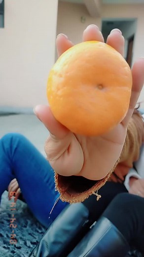 Close-Up of a Hand Holding a Fresh Mandarin